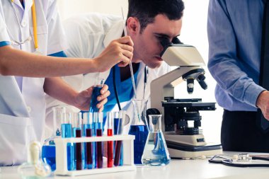 Kimya laboratuvarında çalışan bir grup bilim adamı.