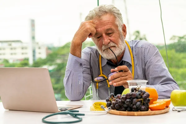 Médecin nutritionniste masculin senior travaillant sur ordinateur portable . — Photo
