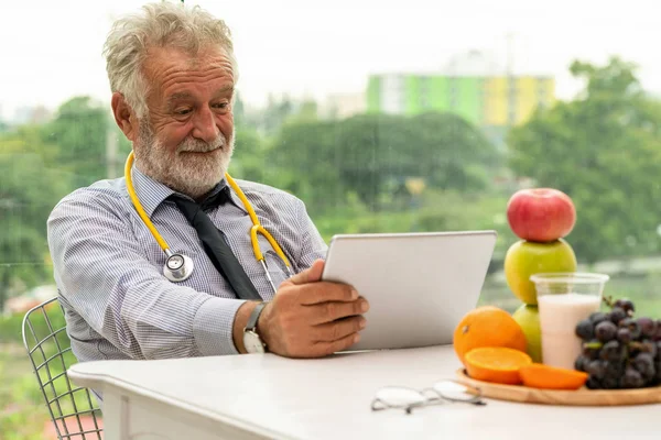 Dizüstü bilgisayar üzerinde çalışan kıdemli erkek beslenme uzmanı doktor. — Stok fotoğraf