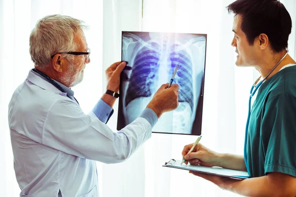 Médicos que trabalham com radiografia de tórax do paciente . — Fotografia de Stock