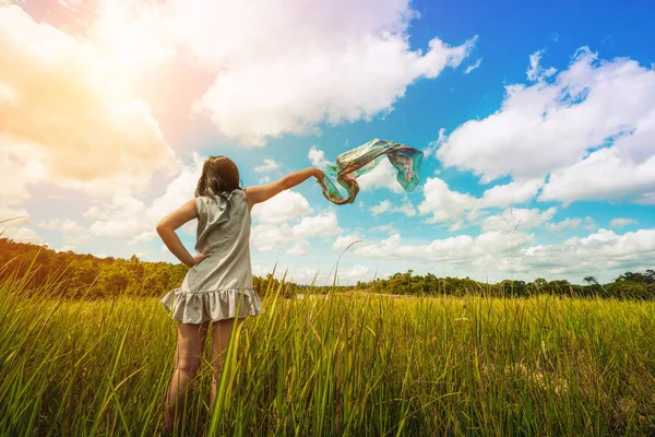 Jonge vrouw op groen gras verspreiden armen naar hemel. — Stockfoto