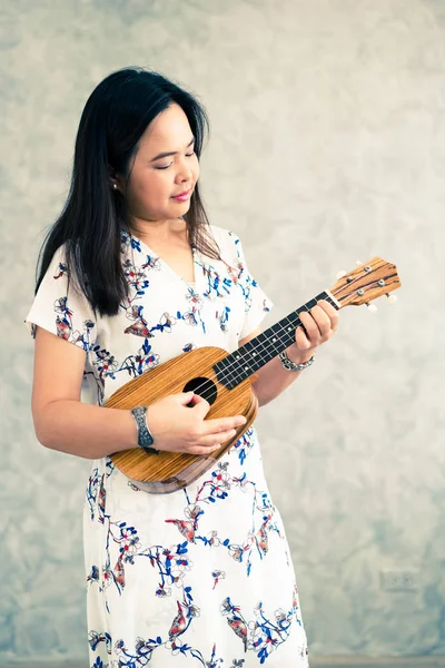 Щаслива жінка-музикант грає укулеле в студії . — стокове фото