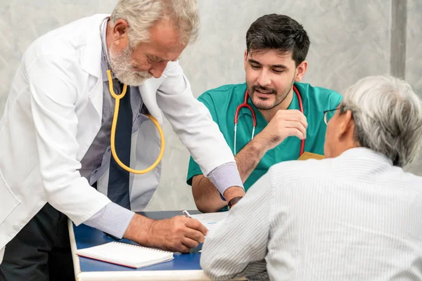 Mannelijke arts team praten met senior patiënt bezoek — Stockfoto