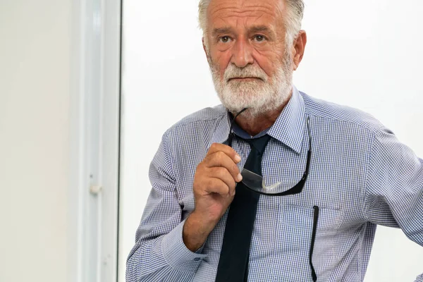 Senior man portret houden brillen in zijn hand. — Stockfoto