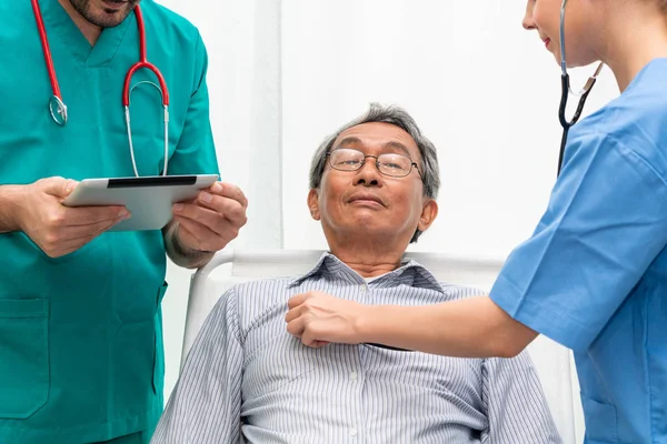 Equipo médico que atiende al paciente adulto mayor . — Foto de Stock