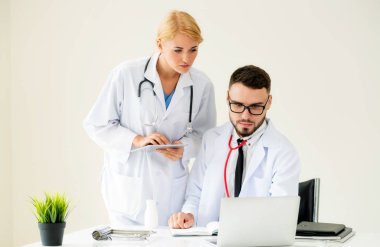 Hastanedeki doktor ortağıyla bilgisayar başında çalışıyor.