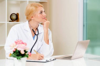 Hastane ofisinde çalışan genç kadın doktor.