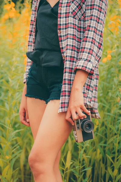 Young woman tourist holds retro style camera. — Stock Photo, Image