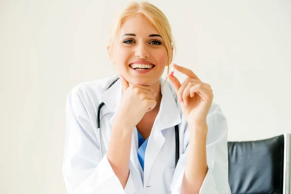 Giovane medico donna in possesso di una pillola medicinale in mano — Foto Stock