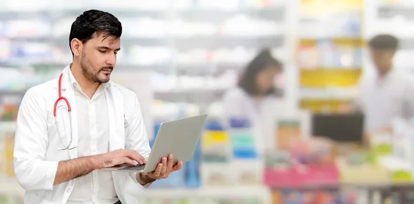 Farmacéutico usando computadora portátil en farmacia . — Foto de Stock