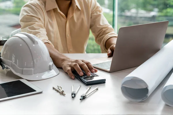 Joven arquitecto o ingeniero que trabaja en el escritorio . — Foto de Stock