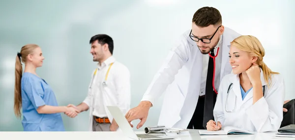 Dokter werkzaam in het ziekenhuis met andere artsen. — Stockfoto