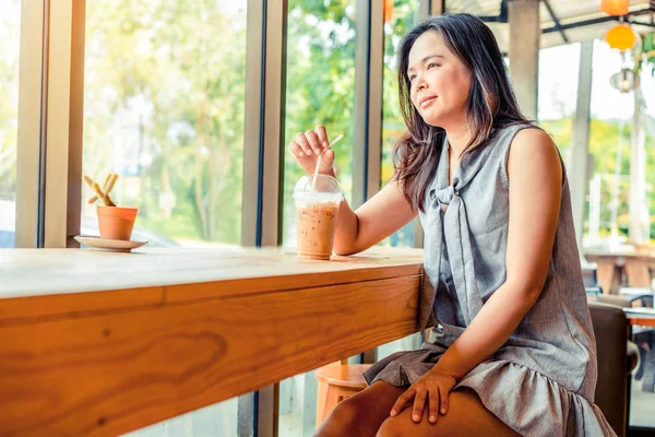 Jeune femme asiatique assis dans un café . — Photo