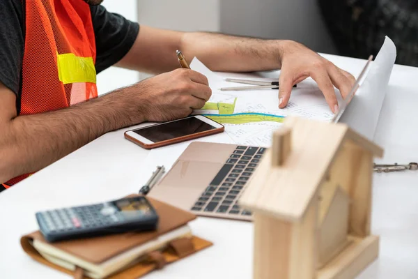 Joven arquitecto o ingeniero que trabaja en el escritorio . — Foto de Stock