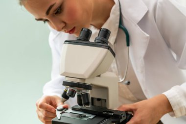 Hastane laboratuvarında mikroskop kullanan doktor.