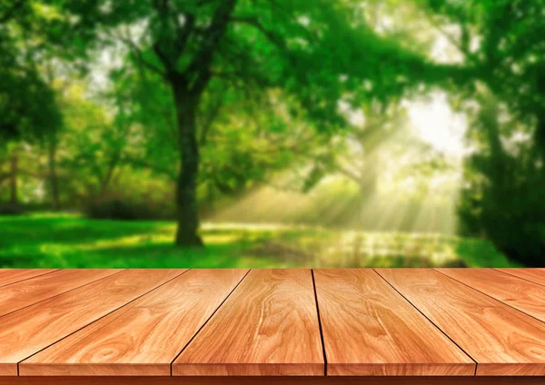 Hnědý dřevěný stůl v pozadí se zelenou rozostřením. — Stock fotografie