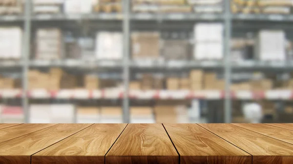 Wood table in warehouse storage blur background.