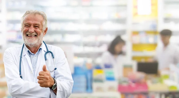 Ευτυχισμένος ανώτερος φαρμακοποιός στέκεται στο φαρμακείο. — Φωτογραφία Αρχείου