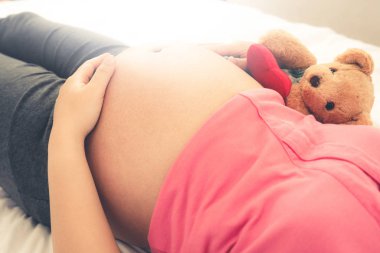 Mutlu hamile kadın yatak odasında uyuyor..