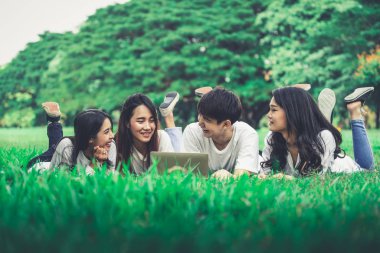 Üniversite veya okul parkında bir grup projesinde okuyan genç öğrencilerden oluşan ekip. Mutlu öğrenme, topluluk takım çalışması ve gençlik arkadaşlık konsepti.