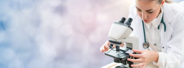 Bilim adamı araştırmacı laboratuvarda mikroskop kullanır