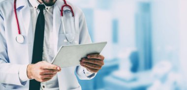 Hastanede tablet bilgisayar kullanan bir doktor..