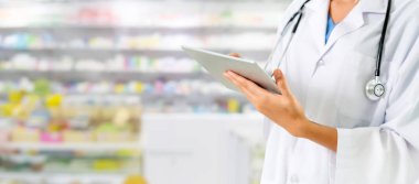 Eczanede tablet bilgisayar kullanan eczacı.