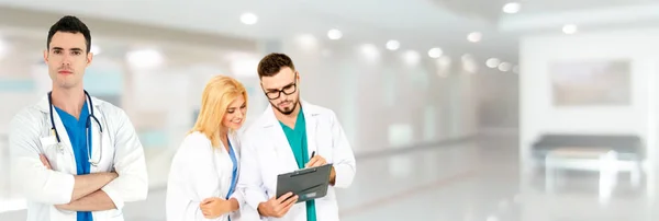 Dokter werkzaam in het ziekenhuis met andere artsen. — Stockfoto