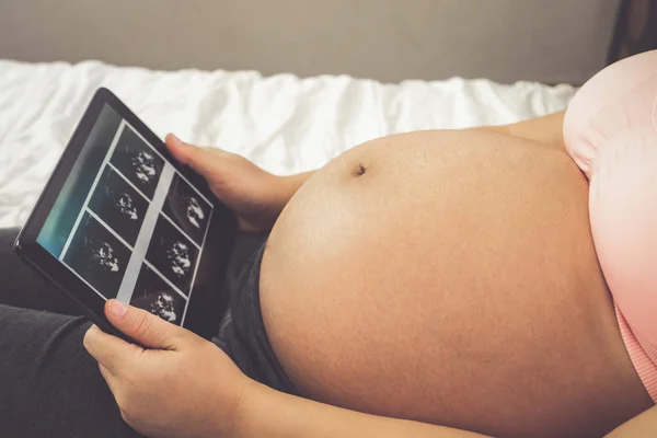 Glückliche Schwangere und erwartetes Baby zu Hause. — Stockfoto