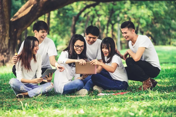 Team av unga studenter som studerar i parken. — Stockfoto