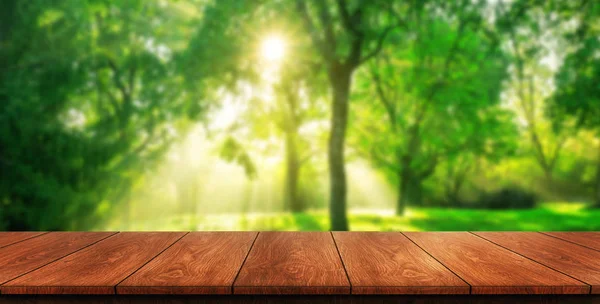 Mesa de madera marrón en fondo de naturaleza borrosa verde . — Foto de Stock