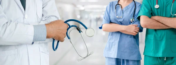 Dokter werkzaam in het ziekenhuis met andere artsen. — Stockfoto