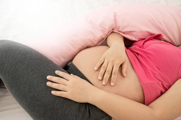 Mujer embarazada feliz durmiendo en la cama en el dormitorio. — Foto de Stock