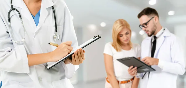 Médico que trabalha no hospital com outros médicos . — Fotografia de Stock