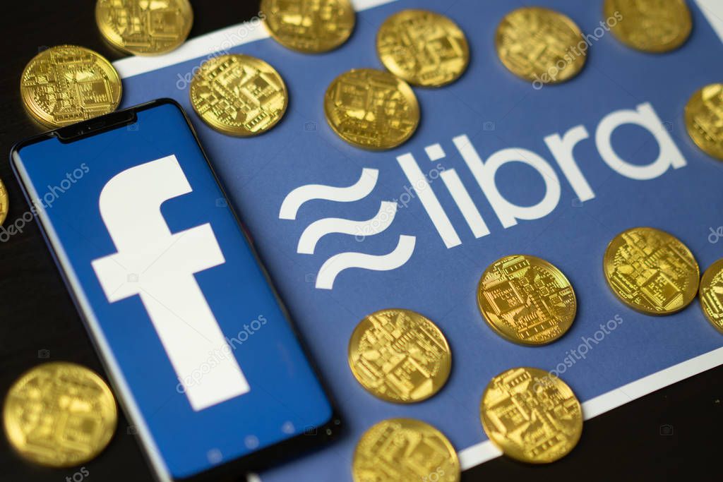 Bangkok, Thailand - July 2, 2019: Phone with Facebook logo on screen is placed on paper with Libra logo. Facebook reported to utilize new cryptocurrency called Libra expected to be used on Facebook.