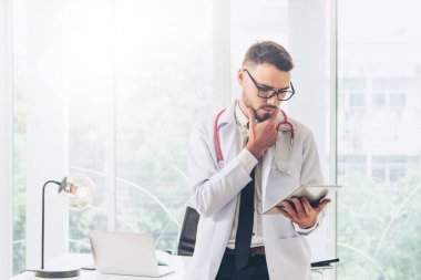 Hastanede tablet bilgisayar üzerinde çalışan doktor.