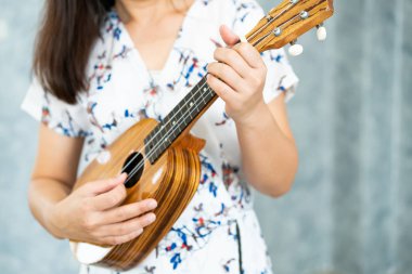 Stüdyoda ukulele çalan mutlu kadın müzisyen.