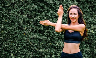 Genç spor kadını parkta sabah egzersizi yapıyor.