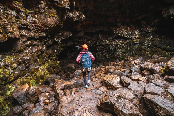 Путешественница исследует лавовый туннель в Исландии . — стоковое фото