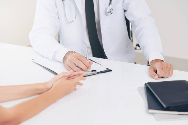 Male Doctor and Female Patient in Hospital Office