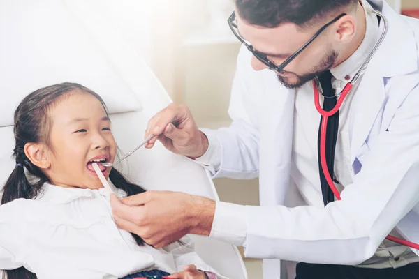 Dentista examinando dientes infantiles en clínica dental . — Foto de Stock