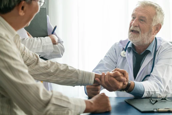 Senior arts praten met de patiënt in het ziekenhuis. — Stockfoto