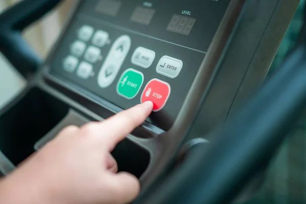 Give Up - Hand pressing stop on treadmill panel.