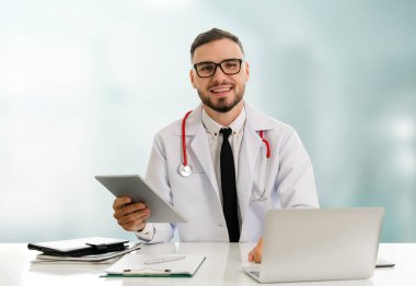 Hastanede tablet bilgisayar kullanan bir doktor..