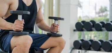 Kaslı adam vücut geliştirmeci dumbbells ile eğitim.