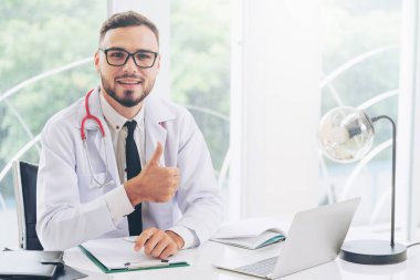 Doktor hastanede başparmak gösteren.