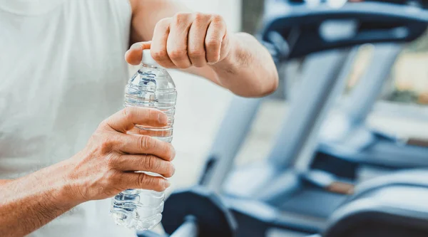 Hombre mayor beber agua mineral en el gimnasio . —  Fotos de Stock