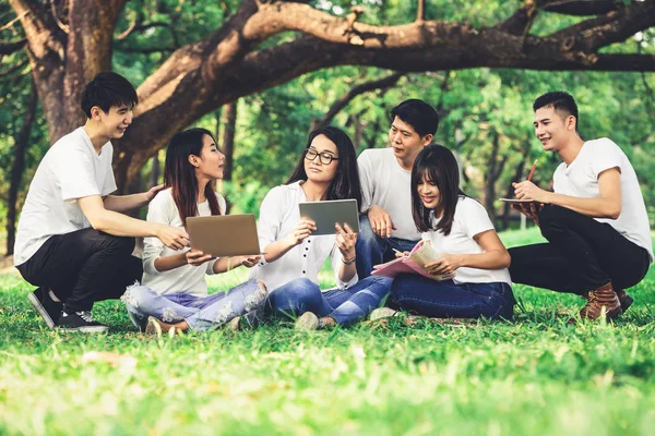 Equipe de jovens estudantes que estudam no parque . — Fotografia de Stock