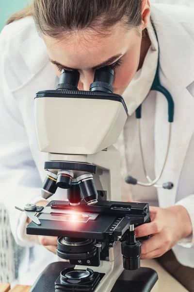 Médico usando microscopio en laboratorio hospitalario . —  Fotos de Stock