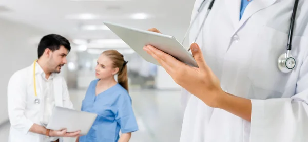 Médico que trabalha no hospital com outros médicos . — Fotografia de Stock